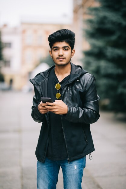 Jovem indiano vestido com roupas da moda, monitoramento de informações de redes sociais