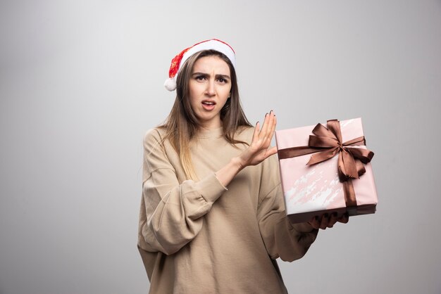 Jovem infeliz com um presente de Natal.