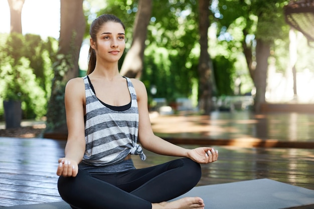 Jovem iniciando sua prática de ioga matinal com meditação e respiração profunda sentada em um templo Conceito de estilo de vida saudável