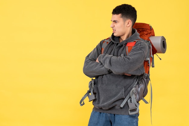 Jovem insatisfeito de frente com a mochila vermelha cruzando as mãos