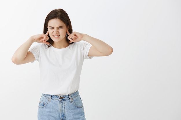 Foto grátis jovem irritada posando contra uma parede branca