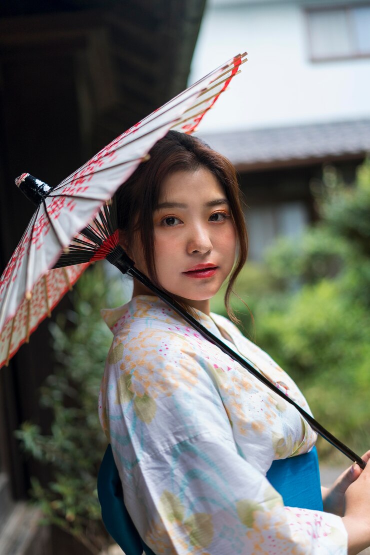 Foto grátis jovem japonesa de quimono e segurando um guarda-chuva