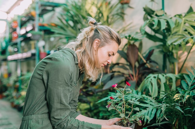 Jovem jardineiro feminino cuidando de plantas