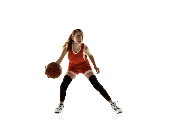 Jovem jogadora de basquete em ação, movimento em execução isolado na parede branca