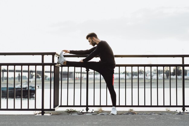 Jovem jogando esportes em uma cidade europeia. Esportes em ambientes urbanos.