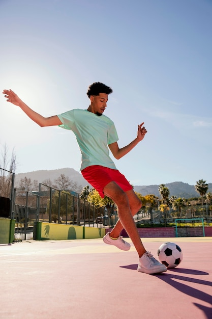 Jovem jogando futebol