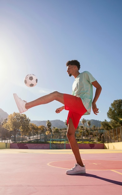 Foto grátis jovem jogando futebol