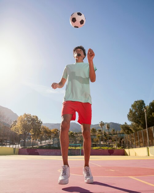 Jovem jogando futebol