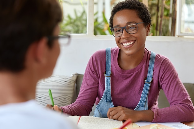 Foto grátis jovem jornalista negra positiva de óculos