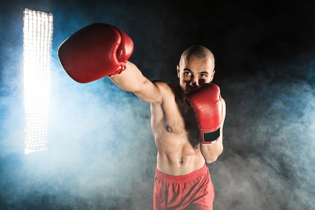 Jovem kickboxing na fumaça azul