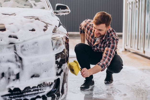 Foto grátis jovem lavando seu carro na lavagem de carros