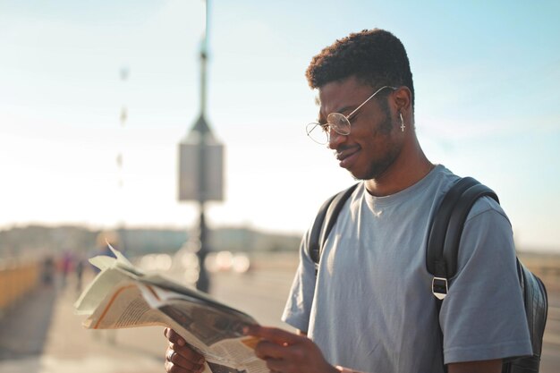 jovem lê um jornal na cidade