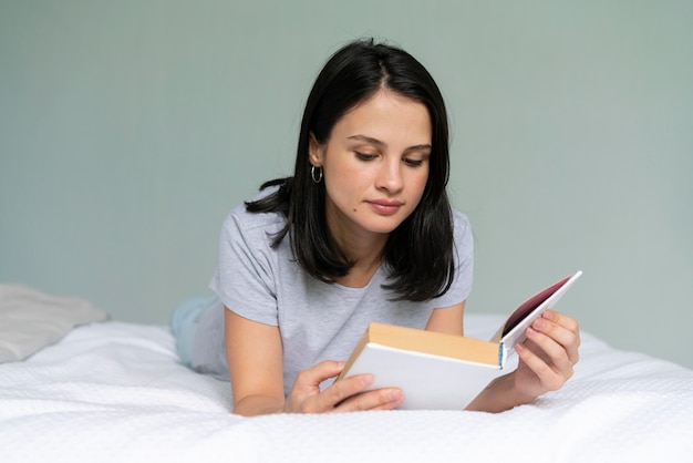 Foto grátis jovem lendo um livro em casa