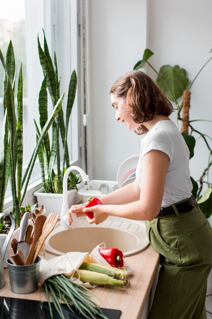 Jovem limpando vegetais orgânicos