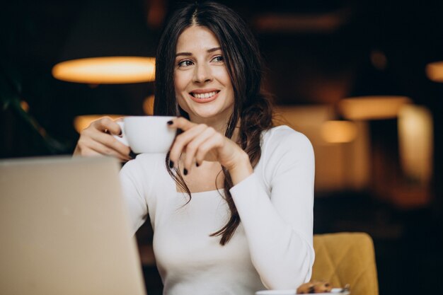 Jovem linda mulher de negócios trabalhando no computador em um café