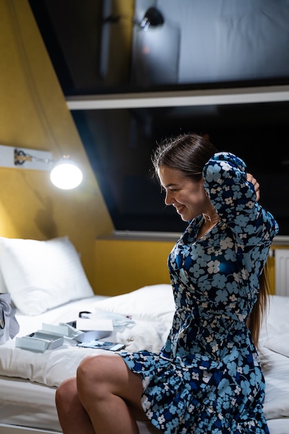 Foto grátis jovem linda viajante se despindo em um quarto de hotel após uma viagem de negócios