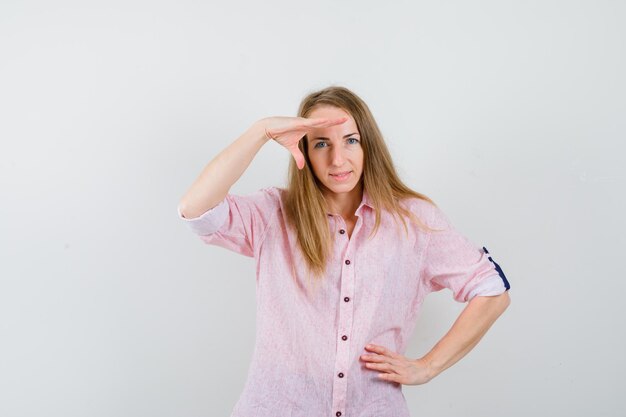 Jovem loira com uma camisa rosa casual