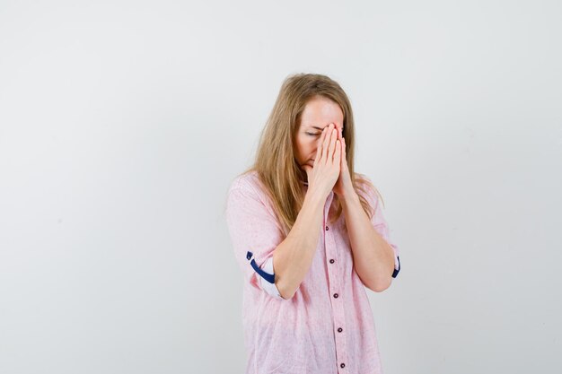 Jovem loira com uma camisa rosa casual