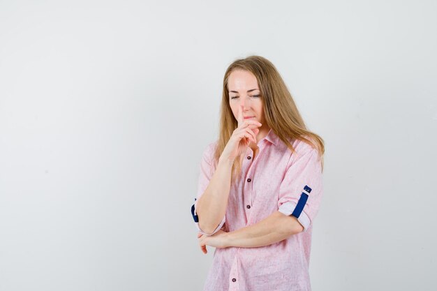 Jovem loira com uma camisa rosa casual