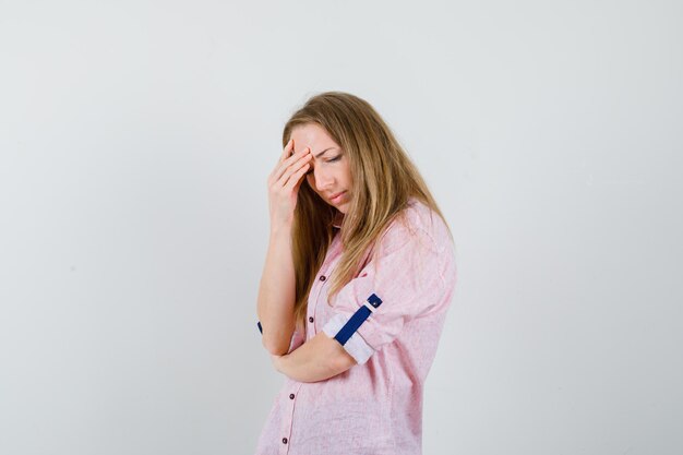 Jovem loira com uma camisa rosa casual