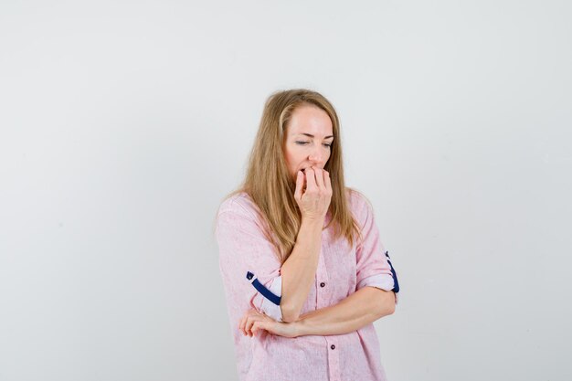 Jovem loira com uma camisa rosa casual