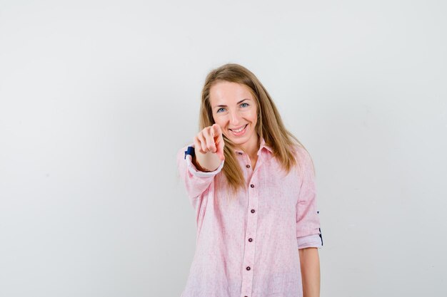 Jovem loira com uma camisa rosa casual