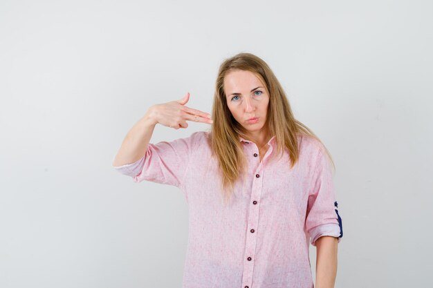 Jovem loira com uma camisa rosa casual