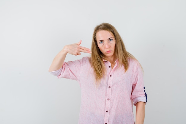 Jovem loira com uma camisa rosa casual