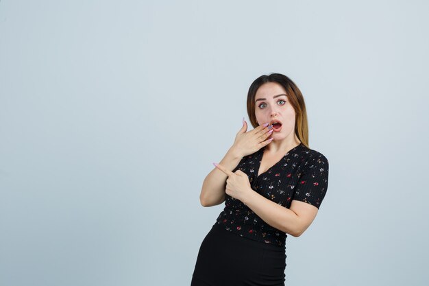 Jovem loira com vestido gesticulando isolada