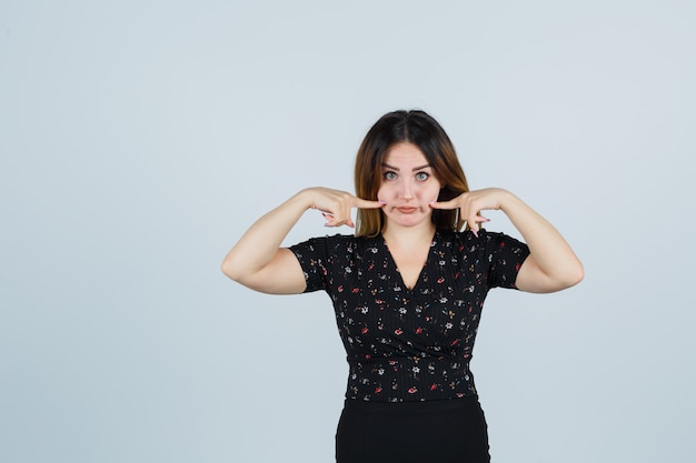 Jovem loira com vestido gesticulando isolada