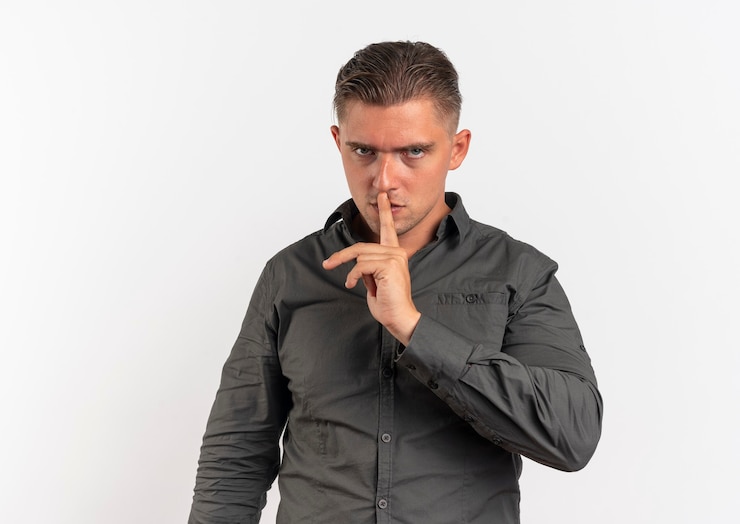 Foto grátis jovem loira confiante com gestos de silêncio, silêncio, sinal de mão isolado no fundo branco com espaço de cópia