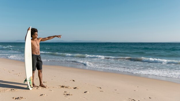 Jovem, macho americano africano, apontar oceano