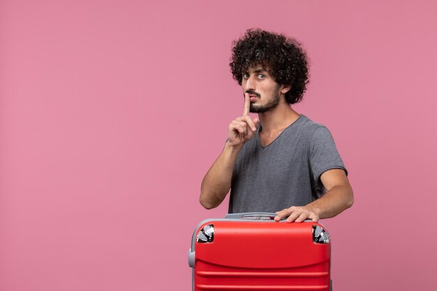 Jovem macho com bolsa vermelha se preparando para uma viagem no espaço rosa