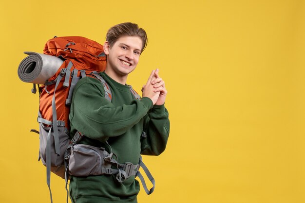 Jovem macho com mochila se preparando para uma caminhada