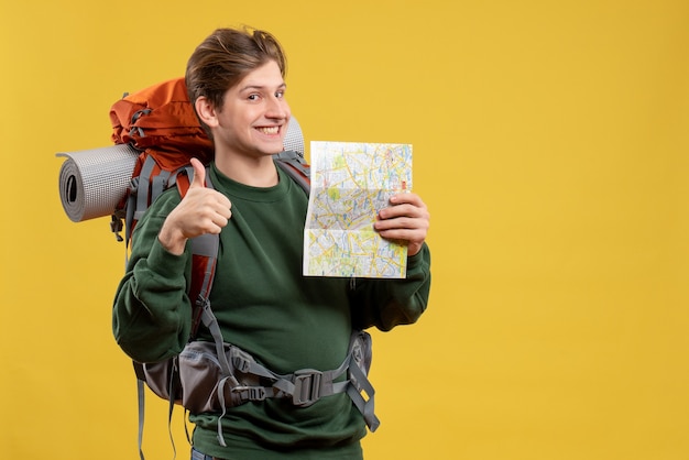 Jovem macho com mochila segurando mapa