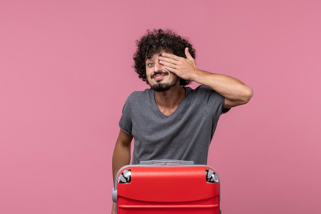 Foto grátis jovem macho com uma grande bolsa vermelha se preparando para uma viagem no espaço rosa