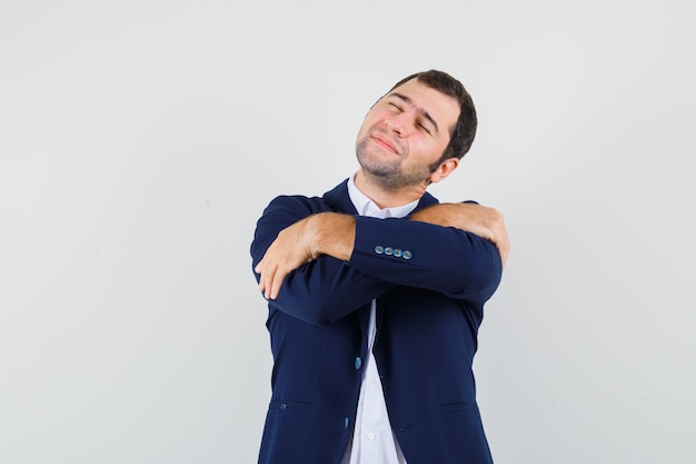 Foto grátis jovem macho se abraçando em uma camisa, jaqueta e parecendo fofo