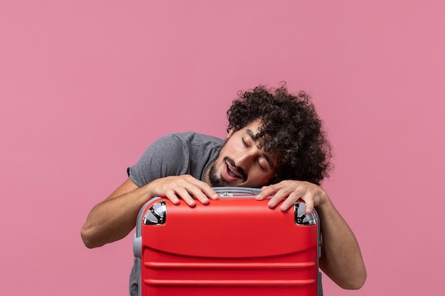 Foto grátis jovem macho se preparando para as férias e se sentindo cansado no espaço rosa