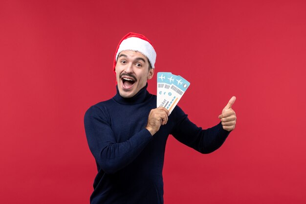 Jovem macho segurando ingressos em fundo vermelho