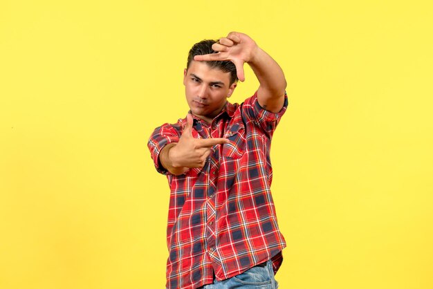 Jovem macho tirando foto em fundo amarelo