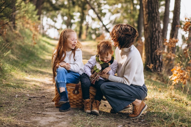 Jovem mãe com filha e filho na floresta