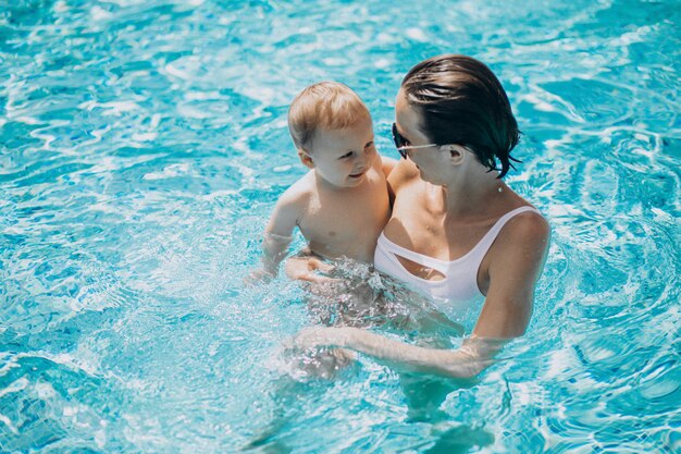 Jovem mãe com filho pequeno em uma piscina