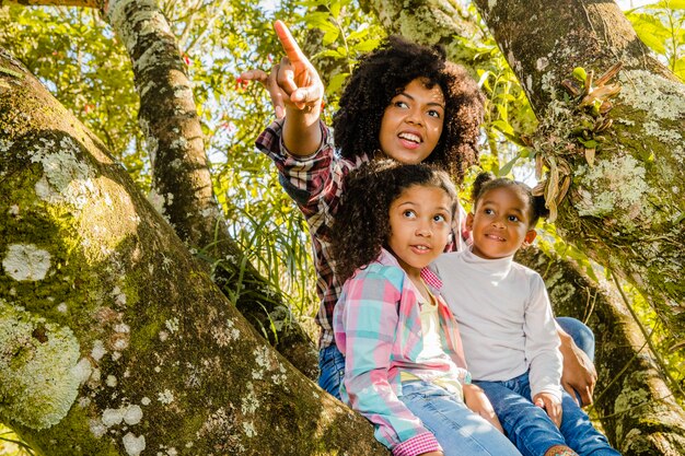 Jovem mãe com filhos em uma árvore