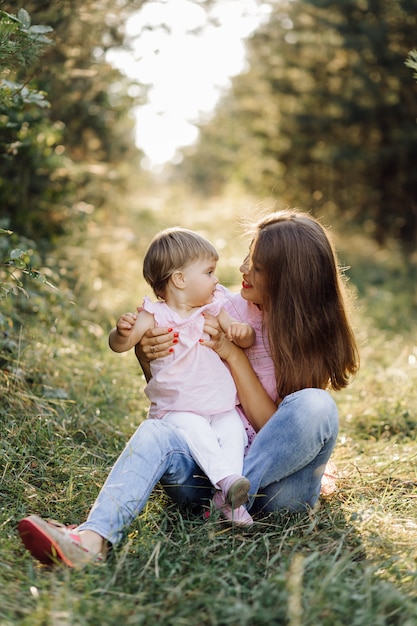 Jovem mãe com seu adorável bebê na floresta