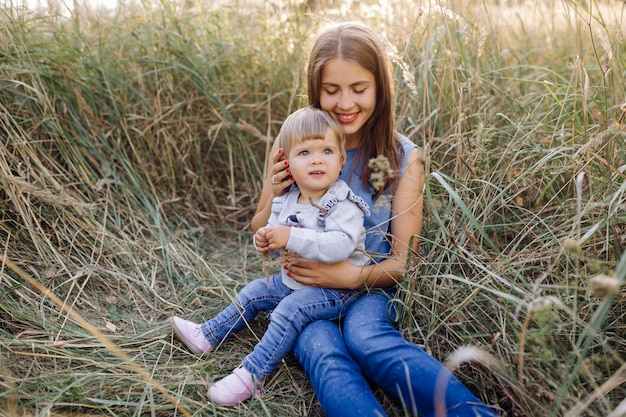 Jovem mãe com seu adorável bebê na floresta