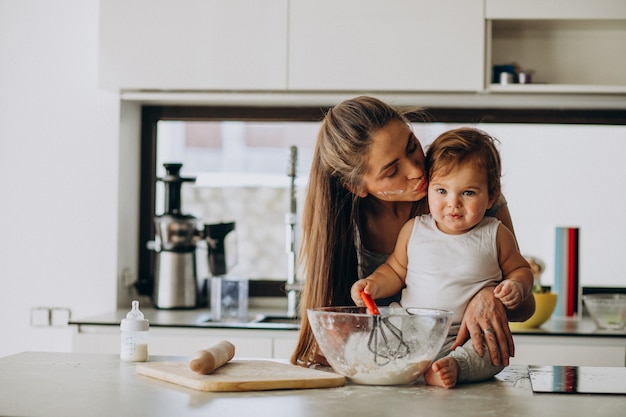 Jovem mãe com seu filho pequeno cozinhando na cozinha