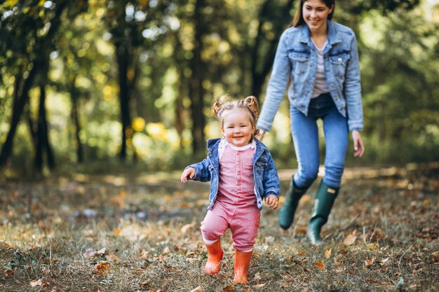 Jovem mãe com sua filha em um parque de outono