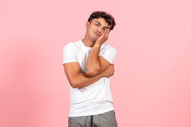 Jovem masculino posando de camiseta branca em fundo rosa