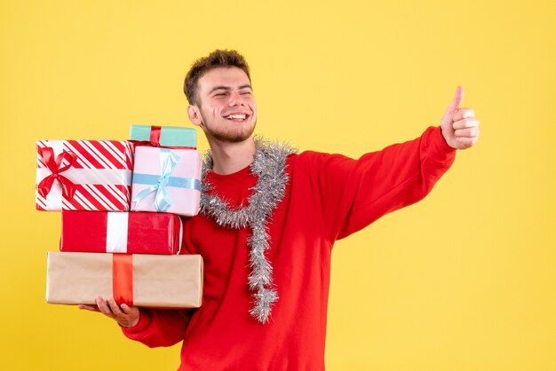 Jovem masculino segurando os presentes de natal