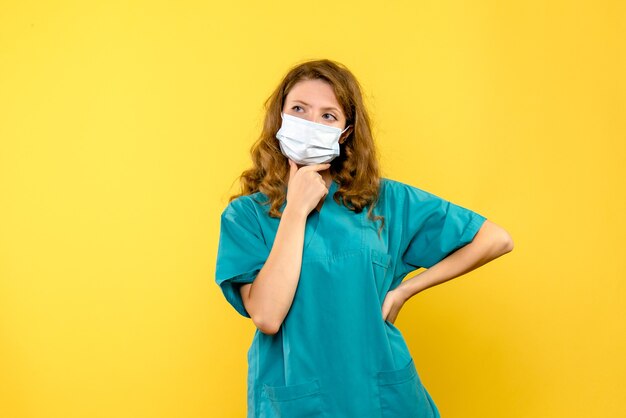 Jovem médica pensando no espaço amarelo de frente